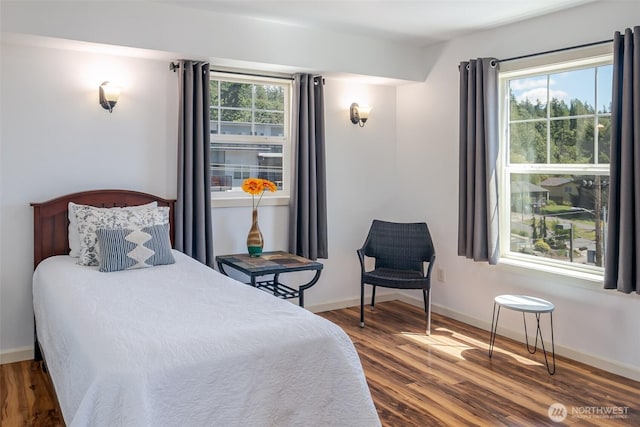 bedroom with wood finished floors and baseboards