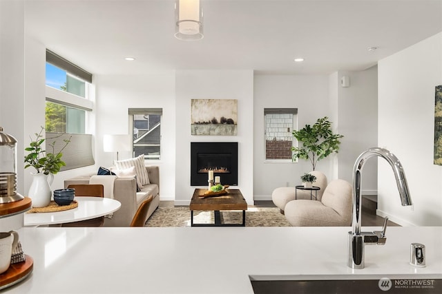 living area with a lit fireplace and recessed lighting