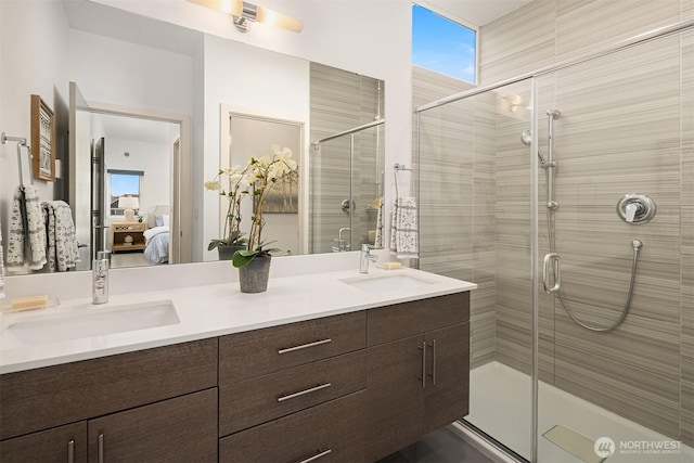 bathroom featuring ensuite bathroom, a stall shower, double vanity, and plenty of natural light