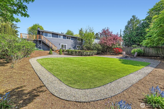 view of yard with stairway, fence, a wooden deck, and a patio area