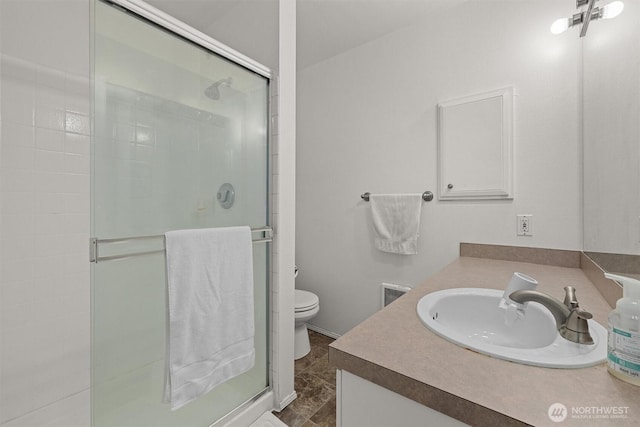 bathroom with vanity, toilet, and a stall shower