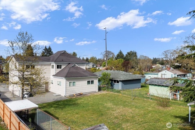 back of property featuring a lawn and fence