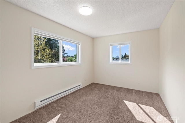 carpeted empty room featuring a baseboard heating unit, a healthy amount of sunlight, and a textured ceiling