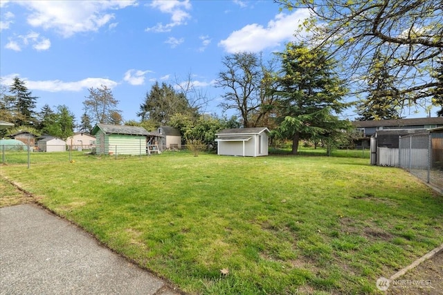 view of yard with a storage shed, fence, and an outdoor structure