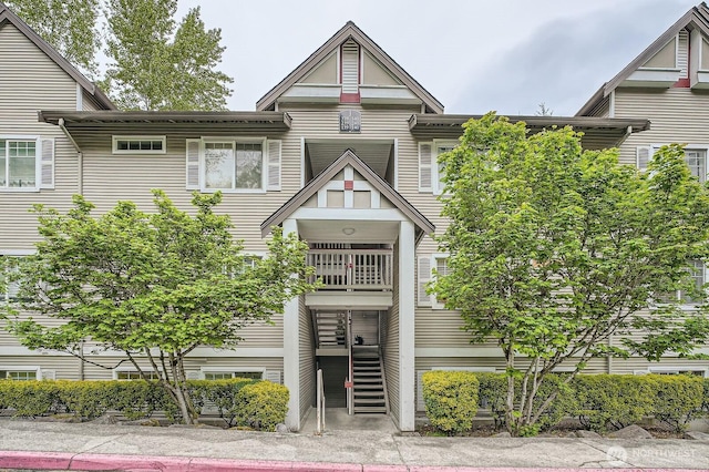 view of front of property with stairs and a balcony