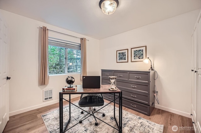 office with baseboards, visible vents, and light wood-type flooring