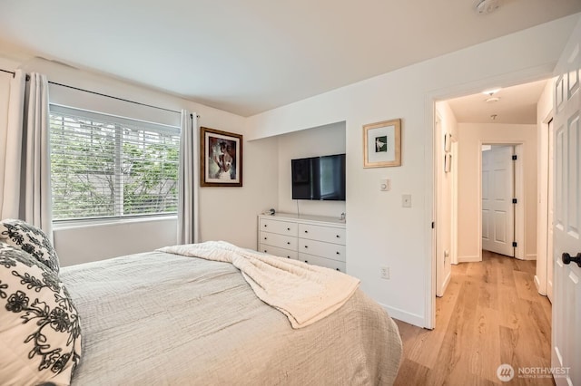 bedroom featuring light wood-style floors and baseboards