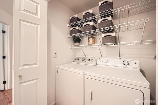 washroom featuring laundry area, light wood-style flooring, and washing machine and dryer