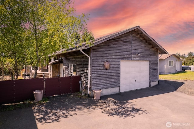 exterior space featuring fence, driveway, and a garage