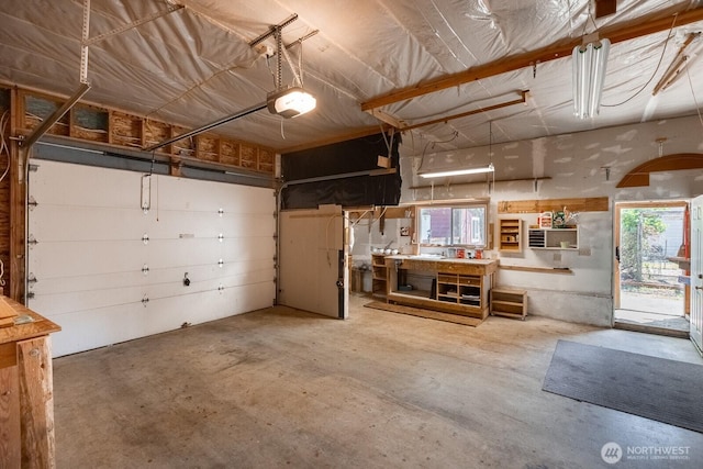 garage with a garage door opener and a workshop area