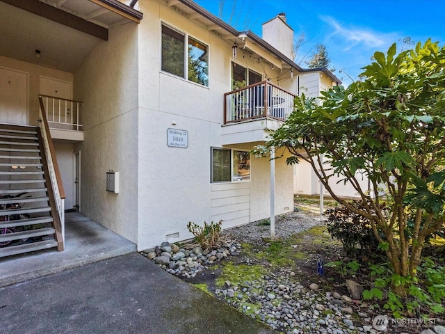 14148 74th Pl NE Unit 12C, Kirkland, WA 98034 - view of side of home with a chimney, stairway, stucco siding, and a balcony