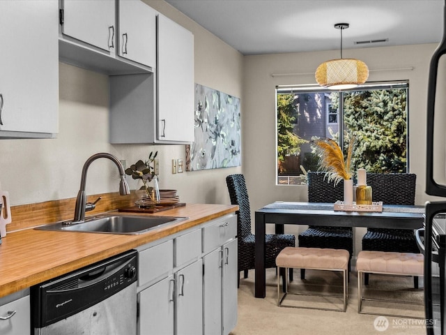 14148 74th Pl NE Unit 12C, Kirkland, WA 98034 - kitchen featuring a sink, visible vents, decorative light fixtures, stainless steel dishwasher, and light colored carpet