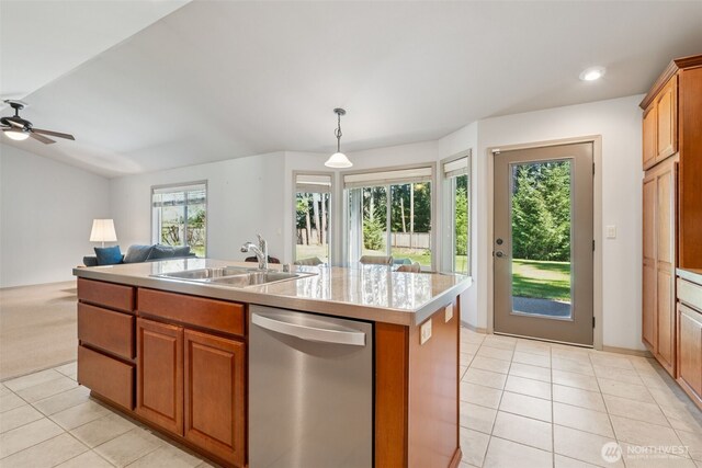 kitchen with light tile patterned flooring, an island with sink, light countertops, a sink, and dishwasher