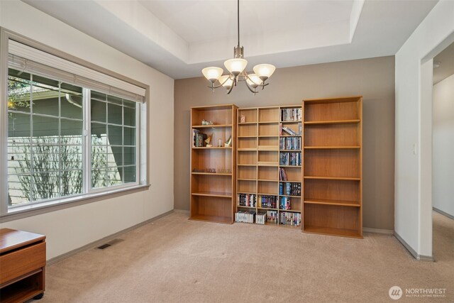interior space featuring visible vents, carpet flooring, a raised ceiling, and an inviting chandelier