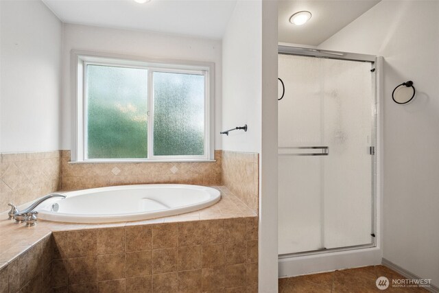 full bathroom with a healthy amount of sunlight, a bath, and a stall shower
