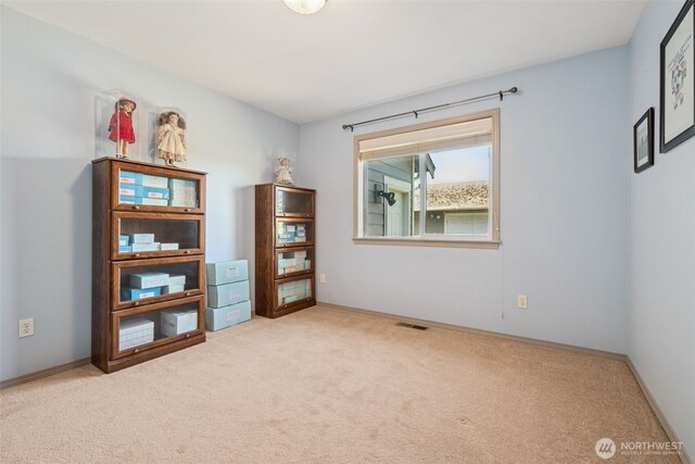 empty room featuring carpet floors, baseboards, and visible vents