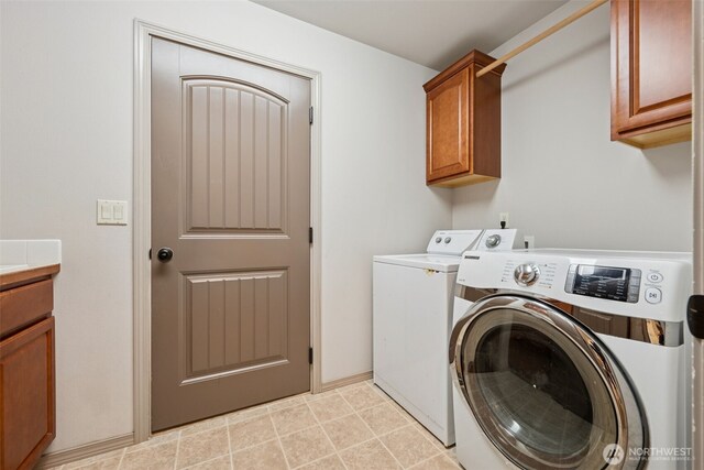 clothes washing area with cabinet space and washer and clothes dryer