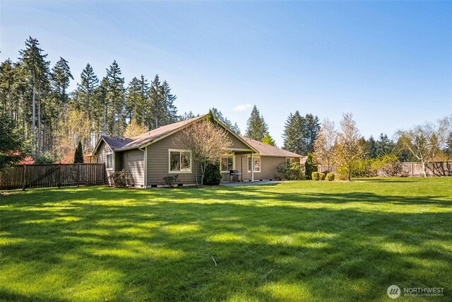 rear view of property with a lawn, a fenced backyard, and crawl space