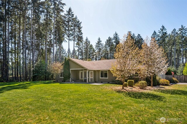 rear view of house featuring a patio, a lawn, and fence