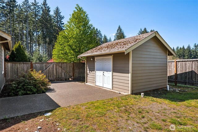 garage featuring fence and a shed