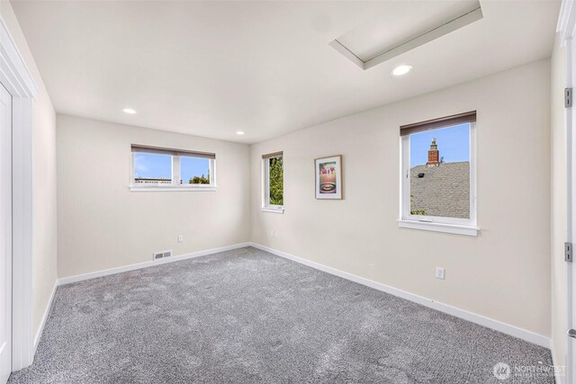 carpeted spare room featuring visible vents, recessed lighting, and baseboards