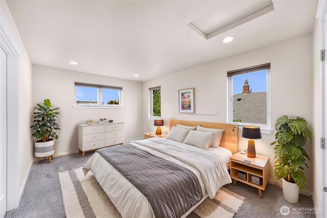 bedroom with baseboards, attic access, carpet, and multiple windows