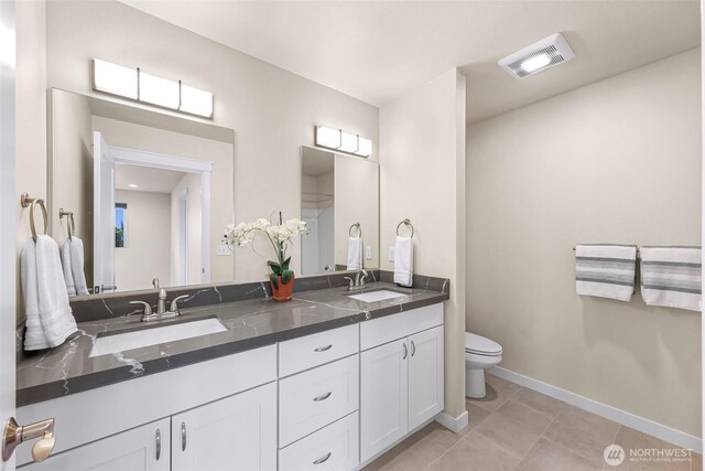 bathroom featuring toilet, visible vents, a sink, and tile patterned flooring