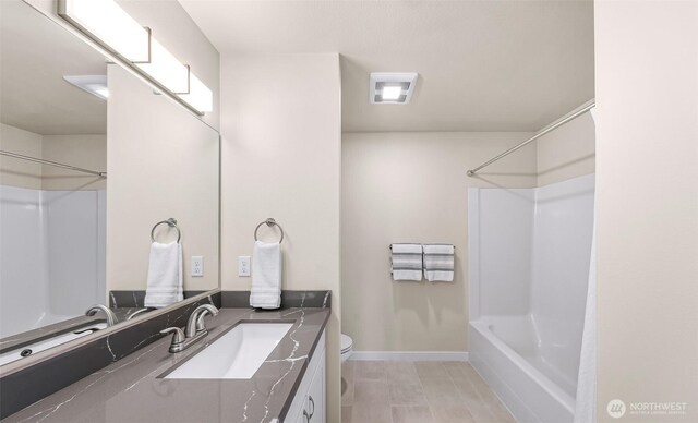 full bath with toilet,  shower combination, baseboards, and vanity