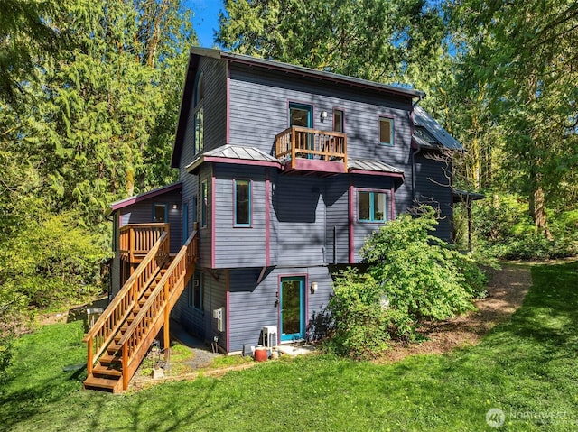 back of property featuring a lawn, a wooden deck, and stairway