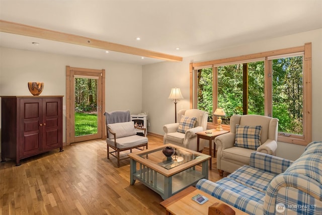 living room with recessed lighting, beam ceiling, and light wood-style floors