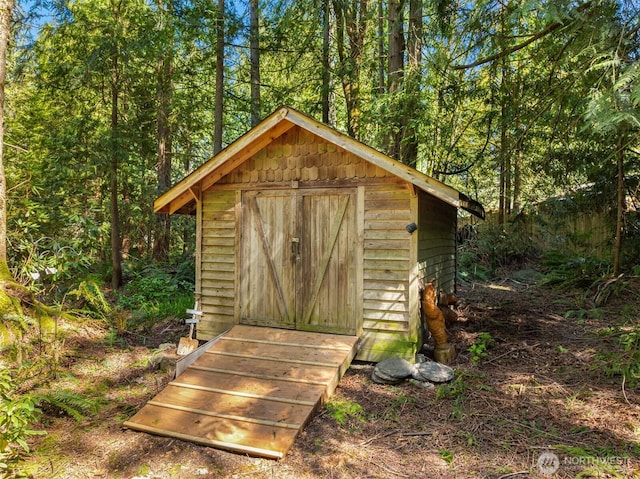 view of shed featuring a view of trees