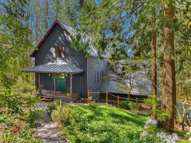 rear view of house with metal roof, a deck, and a standing seam roof
