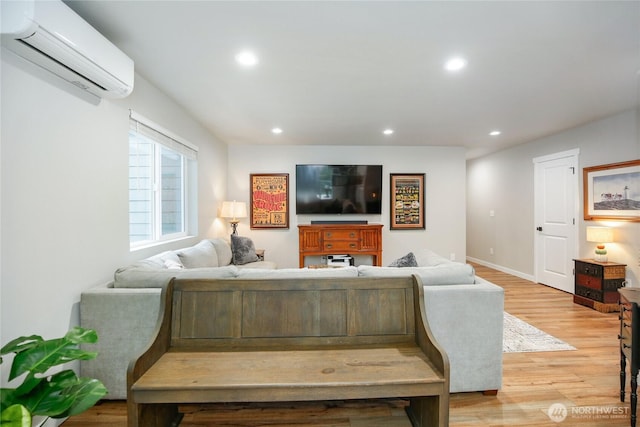 living room with light wood-style flooring, a wall mounted AC, and recessed lighting