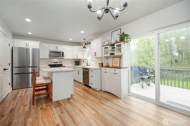 kitchen featuring recessed lighting, stainless steel appliances, open shelves, light wood-style flooring, and white cabinetry