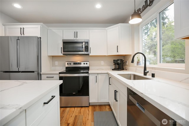 kitchen with recessed lighting, white cabinetry, stainless steel appliances, and a sink