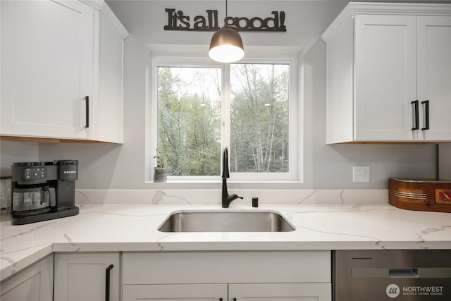 kitchen featuring white cabinets, stainless steel dishwasher, and a sink