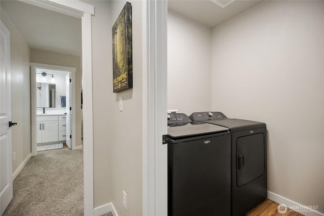laundry area featuring baseboards, washer and dryer, laundry area, and a sink