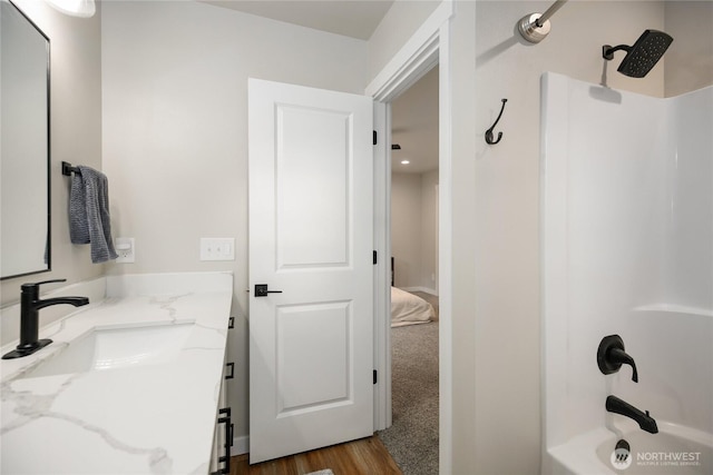 bathroom featuring wood finished floors, shower / bath combination, and vanity