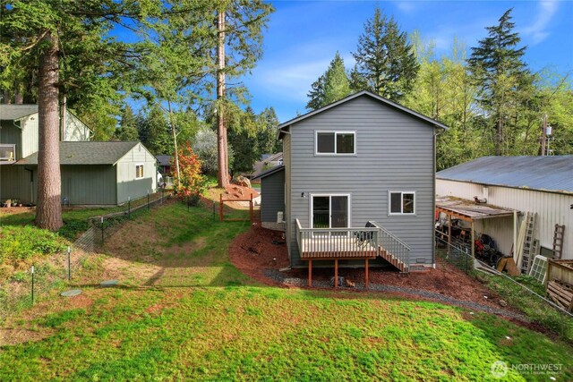 back of property with a yard, fence, and a deck