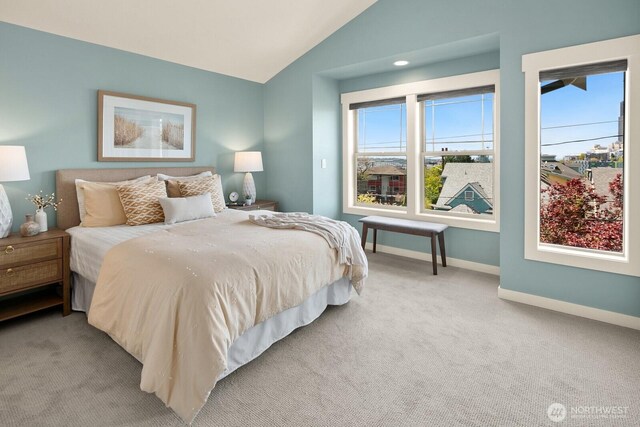 carpeted bedroom featuring lofted ceiling and baseboards
