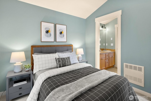 bedroom featuring baseboards, lofted ceiling, a sink, and carpet