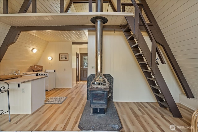 435 Lotloh St SE, Ocean Shores, WA 98569 - interior space with vaulted ceiling with beams, light wood-style flooring, stairway, and a wood stove