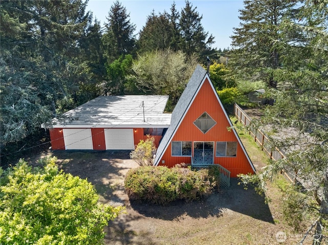 435 Lotloh St SE, Ocean Shores, WA 98569 - a-frame home with fence, a detached garage, and dirt driveway