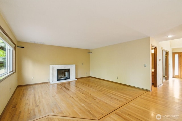 13233 W 44th Ave W, Mukilteo, WA 98275 - unfurnished living room featuring light wood-style flooring, a glass covered fireplace, and baseboards
