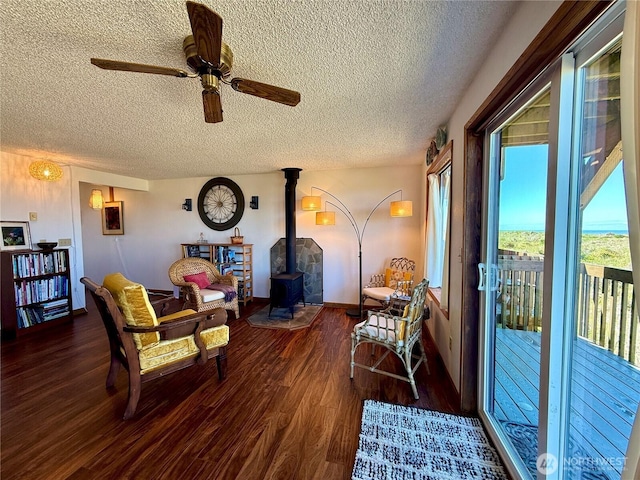1311 Ocean Shores Blvd SW Unit 3, Ocean Shores, WA 98569 - living room featuring a textured ceiling, a wood stove, wood finished floors, and ceiling fan