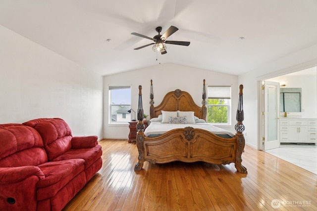 bedroom with baseboards, ceiling fan, connected bathroom, light wood-style flooring, and vaulted ceiling