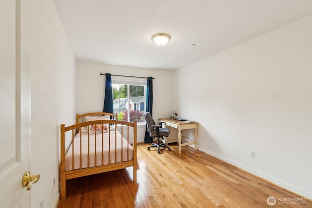 bedroom featuring baseboards and light wood finished floors