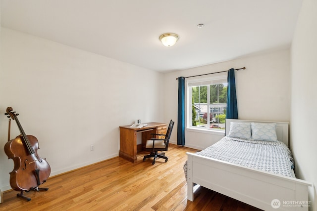 bedroom with baseboards and light wood finished floors
