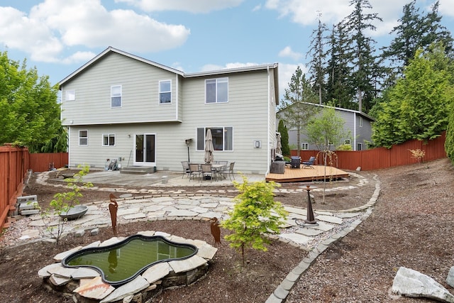 back of house featuring a fenced backyard, a patio area, and a wooden deck