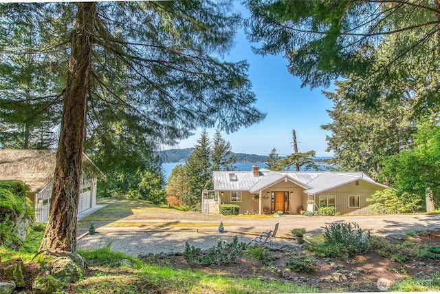 519 Highlands Dr, Orcas Island, WA 98245 - view of front of house with a chimney, metal roof, a garage, and driveway